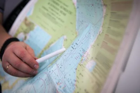 The captain shows the plan of Strait crossing on the map Stock Photos