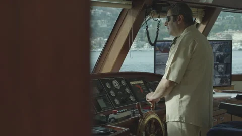 A captain skillfully steers a modern ship from the bridge Stock Footage 325084591