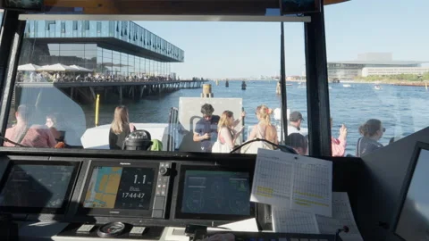 Captain steers harbor bus past Skuespilhuset and the Opera in Copenhagen Stock Footage 344866569