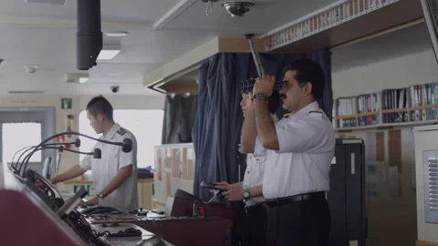 Captain watching through binoculars in freighter cab,singapore Stock Footage 135072259