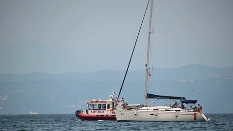 Captaincy government boat checking sailing boat anchored in Adriatic Sea Stock Footage 159019428