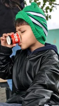 Caption (≤200 characters): Young boy drinking hot tea in the mountains, Stock Photos