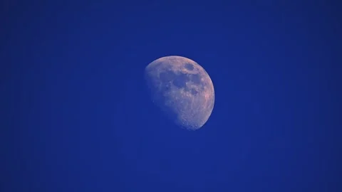 Captivating 4K slow-motion of the moon on a bright blue sky background Vídeo Stock 291886315