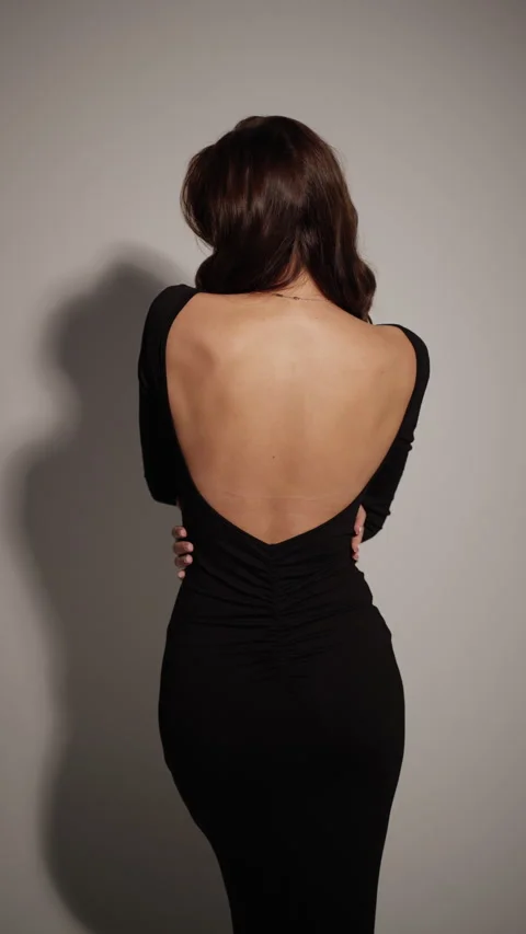 Captivating Backless Dress and Shadow Interplay. Woman captured in a backless 库存影片 268854957
