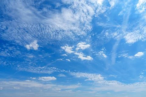 This captivating blue sky features fluffy white clouds scattered across a bri Stock Photos
