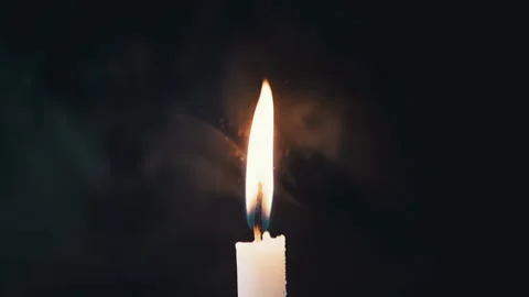 Captivating Candle Flame Dancing on Dark Background with Falling Snow Particles Stock Footage 312014366