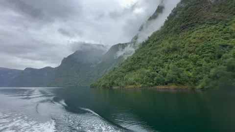 A captivating capture of misty mountains towering over a tranquil waterscape Video stock 314072860