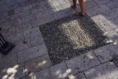 A Captivating Close-Up of Decorative Pebbles Embedded in a Stone Pavement Under Stock Photos