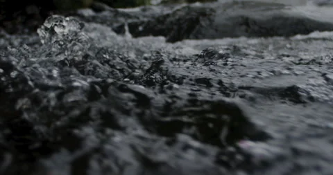 Captivating Close-Up: Slow-Motion Flow of River Current Through beautiful and Stock Footage 240943565