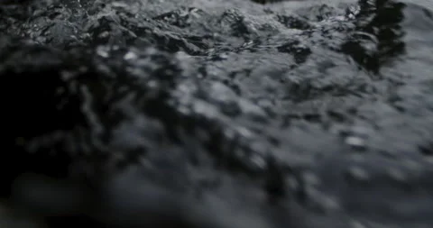 Captivating Close-Up: Slow-Motion Flow of River Current Through beautiful and Stock Footage 240945150