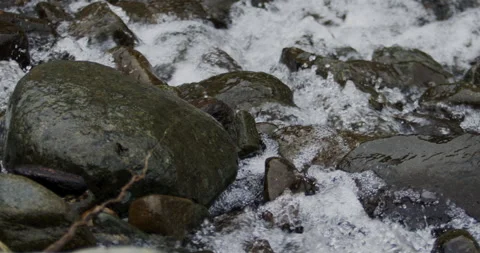Captivating Close-Up: Slow-Motion Flow of River Current Through Stunning Rocks Stock Footage 240947079