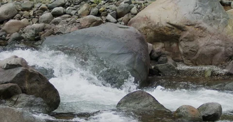 Captivating Close-Up: Slow-Motion Flow of River Current Through Stunning Rocks Stock Footage 240952701