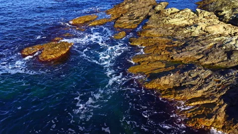 Captivating coastal scene featuring rocky shorelines kissed by gentle ocean Stock Footage 335357206