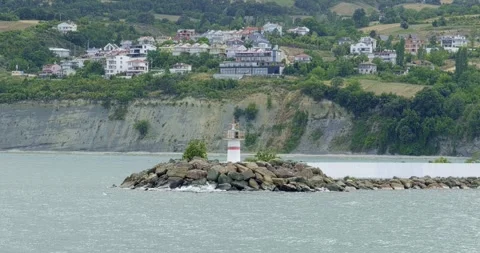 A captivating daytime view of a lone lighthouse in the middle of the sea Stock Footage 296586614