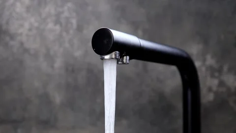 Captivating flow of water from a sleek modern faucet in an urban setting Vidéo 296314771