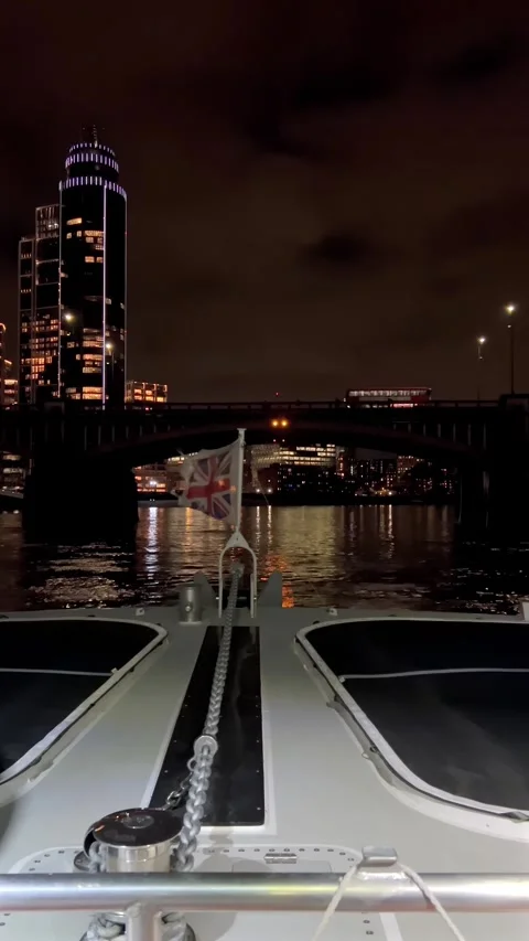A captivating night cruise on river Thames, passing under a bridge with Lon.. 库存影片 339347843