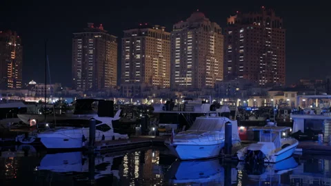 Captivating nighttime view of a marina featuring beautifully illuminated Stock Footage 303379464