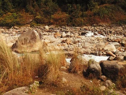 A captivating river flows gently, embraced by magnificent mountains Stock Photos