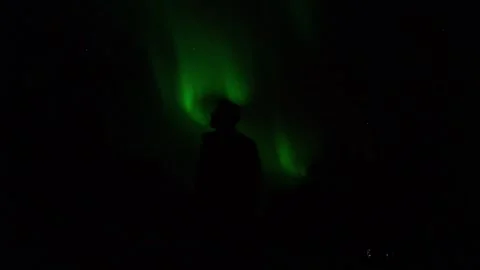A captivating scene of a man standing in front of the Northern Lights in Norway 스톡 동영상 308729506