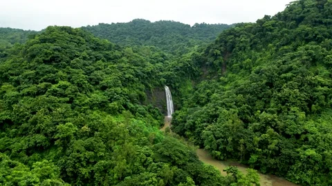 A captivating scene moving toward a waterfall nestled in the mountains. Surround Video stock 287768470