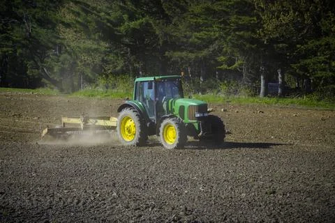 Captivating scene of a tractor skillfully plowing a picturesque rural field. Stock Photos