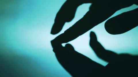 Captivating silhouette of hands gently touching the surface of water. Video stock 284912638