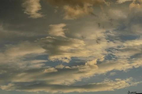 Captivating sunset clouds paint the evening sky in warm hues and delicate s.. Stock Photos