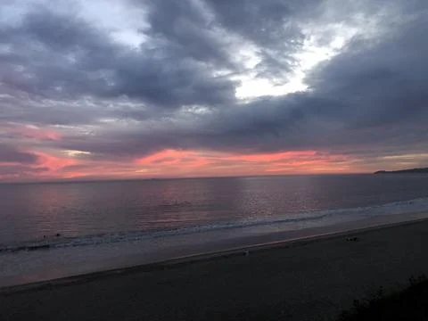 Captivating Sunset Over Tranquil Beach With Vibrant Sky Hues Stock Photos