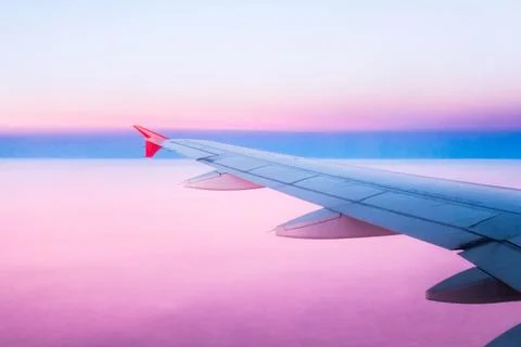 Captivating sunset view from an airplane wing during a flight above the clouds Stock Photos