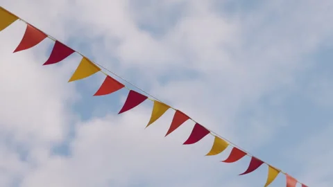 Captivating Triangular Flags Dancing in the Breeze Against a Clear Blue Sky with Stock Footage 318526677