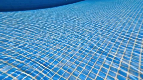 The captivating underwater pool surface displays a grid pattern accompanied by Stock Footage 311212628
