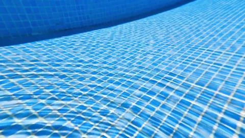 The captivating underwater pool surface displays a grid pattern accompanied.. 스톡 사진