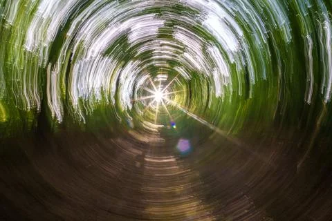 A captivating view of bright light shining through a circular green tunnel, e Stock Photos