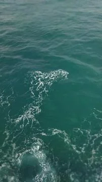 A captivating view of the ocean's surface.  Teal waters, gentle waves, and wh Stock Photos