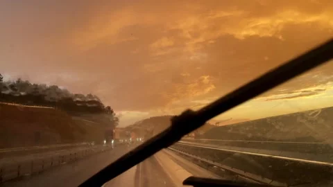A captivating view of a rainy sunset drive with vibrant colors and reflections Stock Footage 315654747