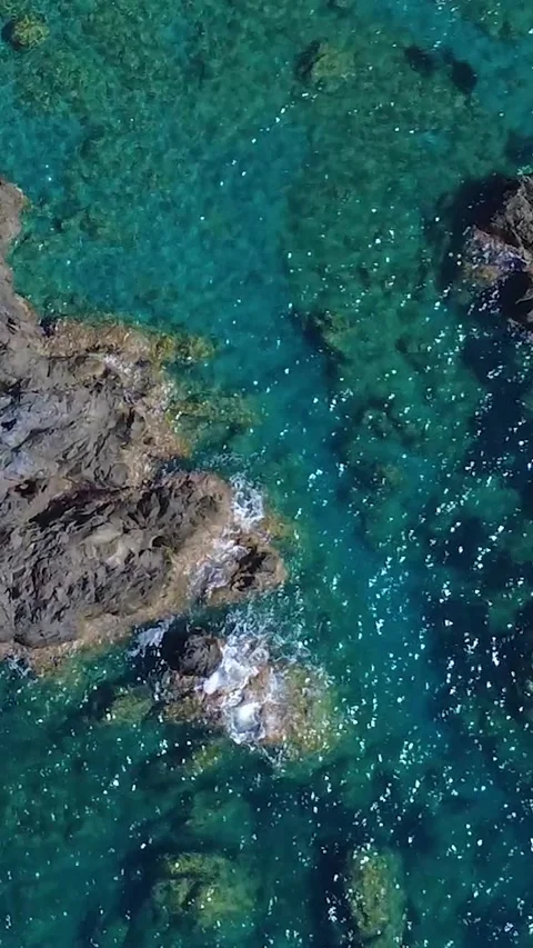 Captivating View of Rocky Coastline With Clear Blue Water on a Sunny Day in a Stock Footage 317750655