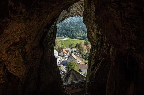 Captivating view of village from deep inside Predjama Castle Cave. Slovenia Stock Photos