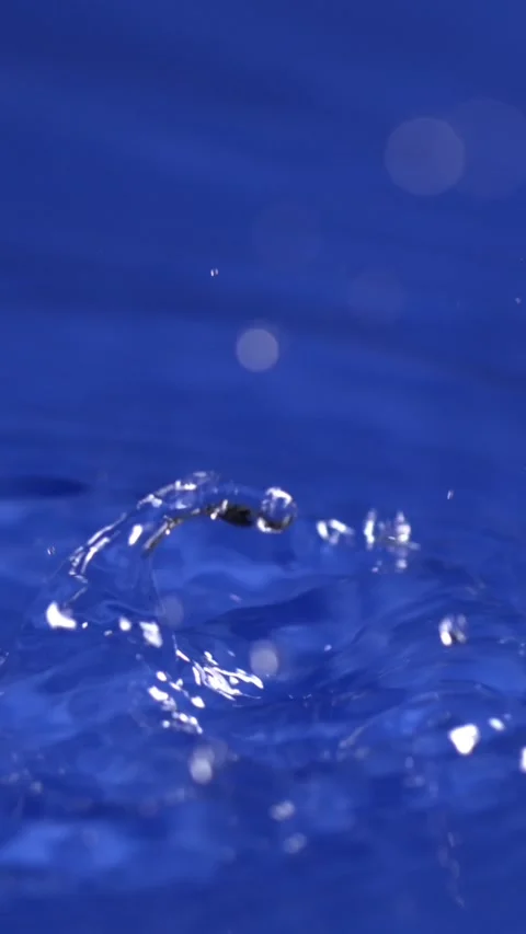 Captivating water droplets create mesmerizing patterns in a vibrant blue pool Stock Footage 322815481