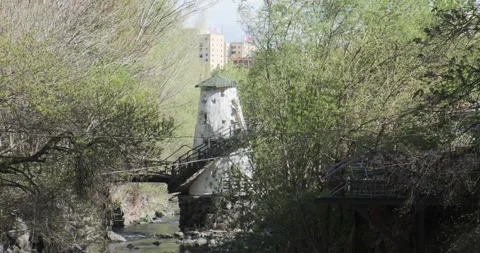 Capture the beauty of a small bridge spanning a rocky river amid lush foliage Video stock 252467241