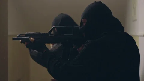 Capture group in masks with automatic guns with laser sights enters in the house Stock Footage 103122771