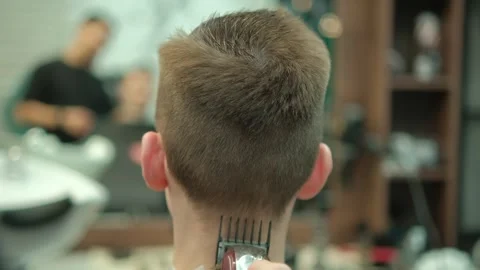 Capture the rear view of a modern hairstyle being styled during a haircut Stock Footage 276339833