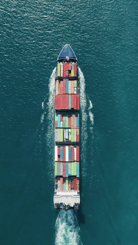 Capture a vertical video of a cargo ship with colorful containers at sea from an Vidéo 276767822