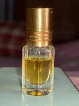 Captured in this image is an elegant small glass bottle filled with a golden  Foto stock