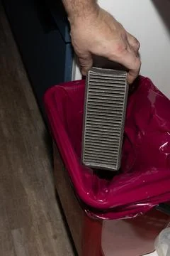 Capturing conclusion of filter replacement by placing spent cabin filter i Stock Photos