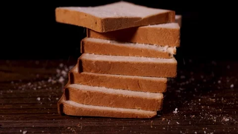 Capturing dynamic falling bread slices on a wooden surface creates a lively 動画素材 277423494