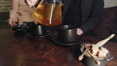 Capturing intimate moment of tea pouring from teapot to cup Video stock 331884712