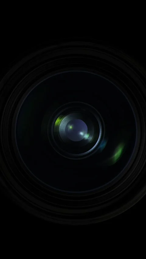 Capturing light reflections through lens elements in a dark room at dusk Stock Footage 317309774