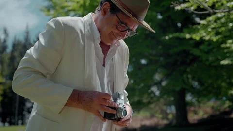 Capturing moments with an analog camera in a serene park setting Stock Footage 321372027