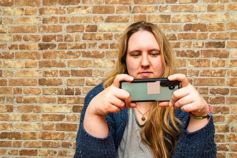 Capturing Moments in a Cozy Setting with a Beautiful Mother Using Her Smart.. Stock Photos
