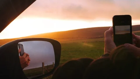 Capturing a sunset with a phone from the car Stock Footage 97540173